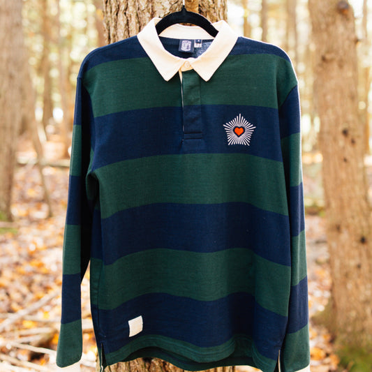 Striped sweater with a heart design hanging on a tree in a forest setting