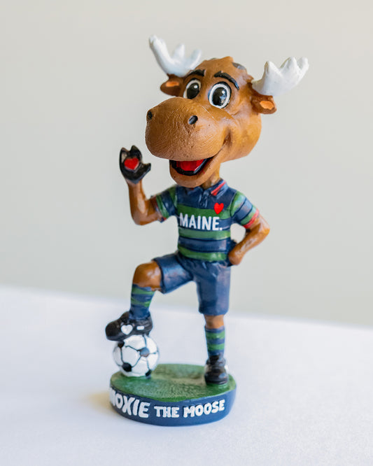 Bobblehead of a moose character wearing a Maine shirt with a soccer ball on a white background