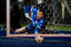 Soccer goalkeeper in blue uniform diving to save a ball on a soccer field